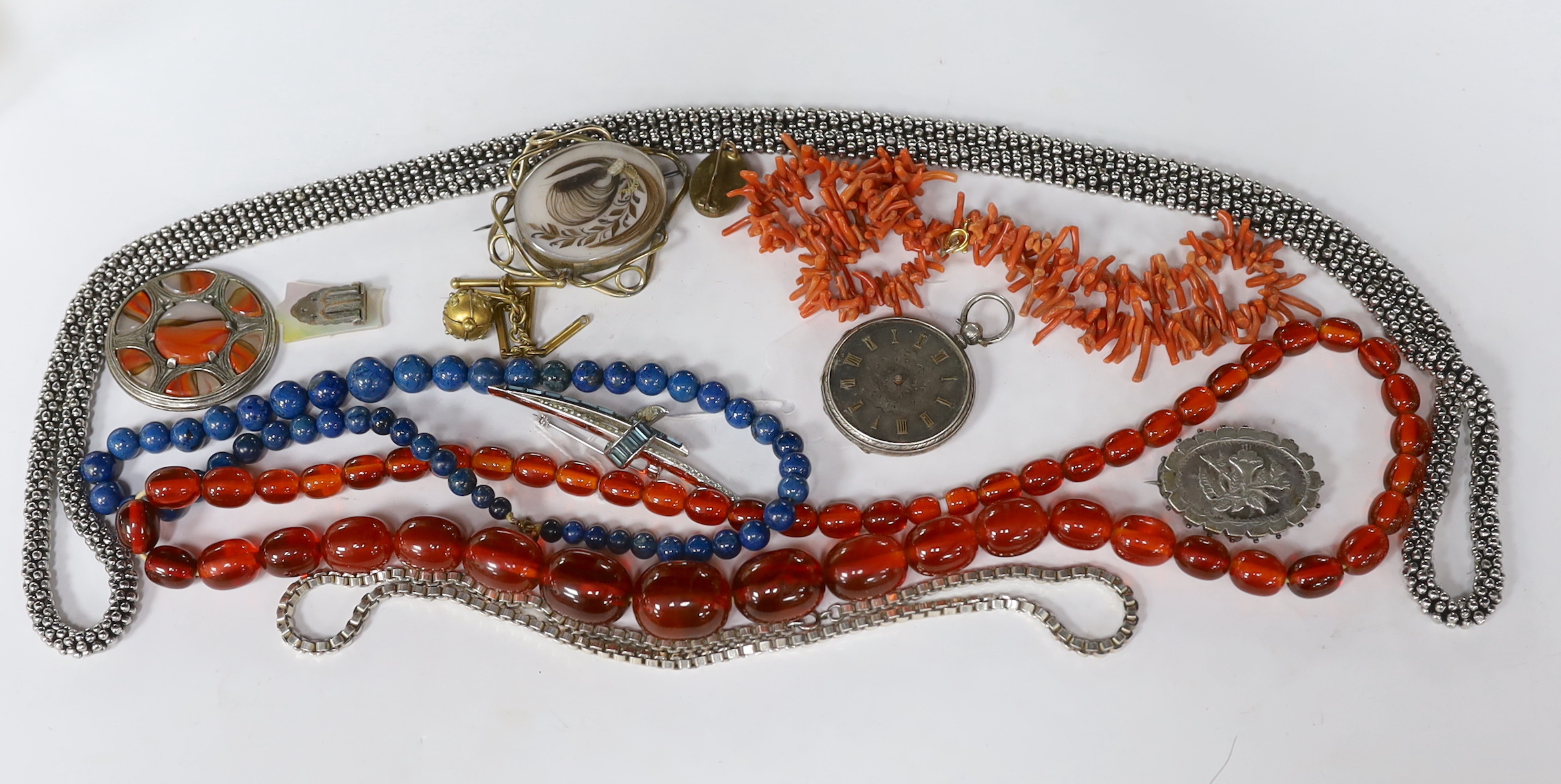 Assorted jewellery including a graduated simulated amber bead necklace, coral branch necklace, white metal oval brooch, Victorian mourning brooch etc.